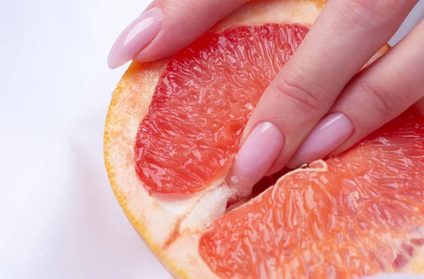 female fingers in grapefruit, woman masturbation and sex concept. Vagina and clitoris symbol.