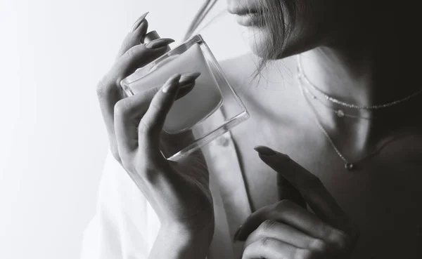 Young woman and perfume in black and white