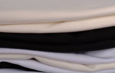 Gri arkaplanda çeşitli tişörtler yığını