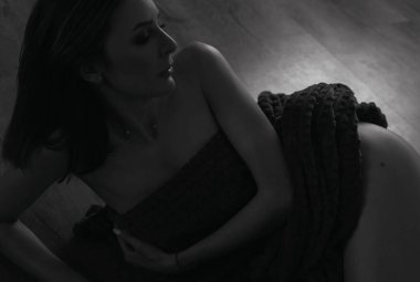 Güzel seksi kadın gri bir ekosenin altında yatıyor.