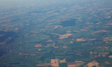 Büyük yükseklikte uçan uçağın penceresinden kara yüzeyinin görüntüsü