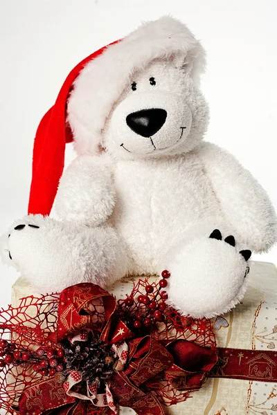 Urso de brinquedo bonito com presente de Natal e chapéu de Papai Noel no backgro branco Imagens Royalty-Free