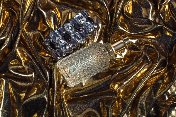Egy üveg parfüm fényes arany háttér — Stock Fotó