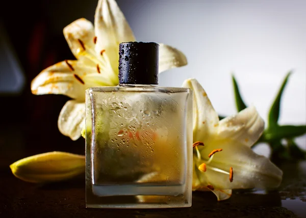 Parfum met groene bloemblaadjes — Stockfoto