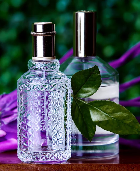 Dois perfumes sobre um fundo verde — Fotografia de Stock
