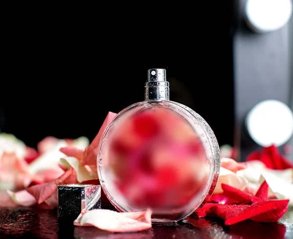 Perfumy z czerwonych kwiatów na czarnym tle — Zdjęcie stockowe