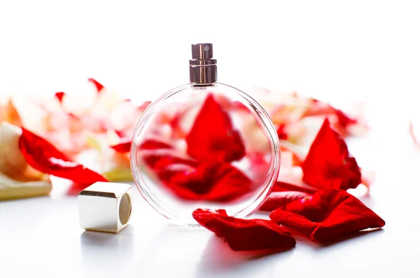 Perfume bottle with petals on table close-up — Stock Photo, Image