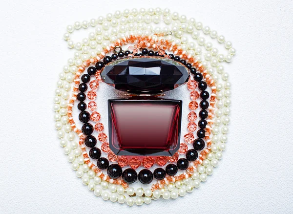Parfémy a náhrdelník izolovaných na bílém pozadí. — Stock fotografie