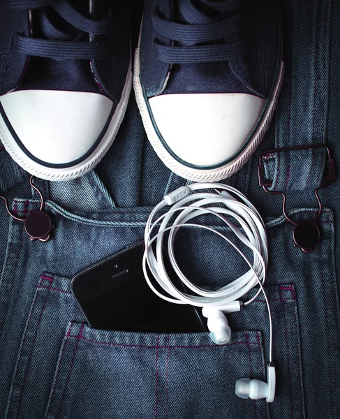 Tênis jeans elegantes e gadgets — Fotografia de Stock