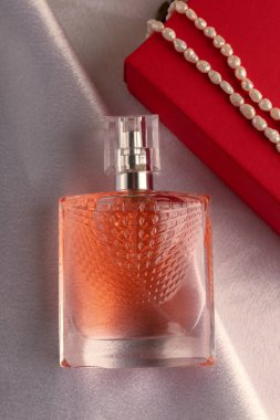 Bir şişe parfüm ve beyaz inci.