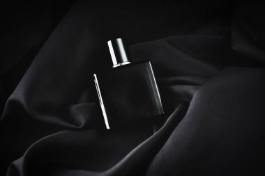 Siyah arka planda erkek parfümü. Erkekler Günü.