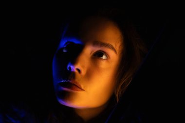 Portrait of a young woman in blue and yellow lights