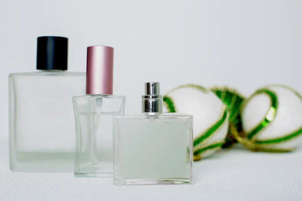 Garrafas de perfume e bolas de Natal sobre branco — Fotografia de Stock