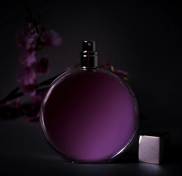 Weibliches Parfüm mit rosa Blume über schwarz — Stockfoto