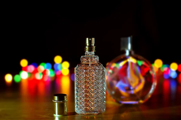 Flakon perfum na tle światła Bożego Narodzenia. — Zdjęcie stockowe