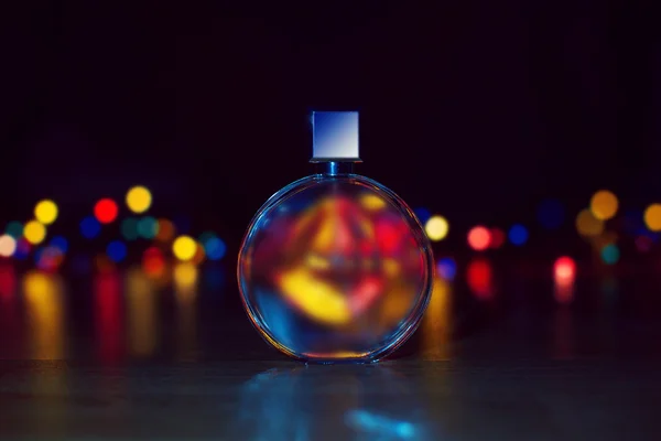 Flakon perfum na tle światła Bożego Narodzenia. — Zdjęcie stockowe