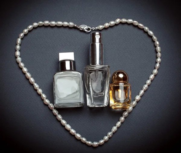 瓶的香水和白色的珍珠。妇女的配件 — 图库照片