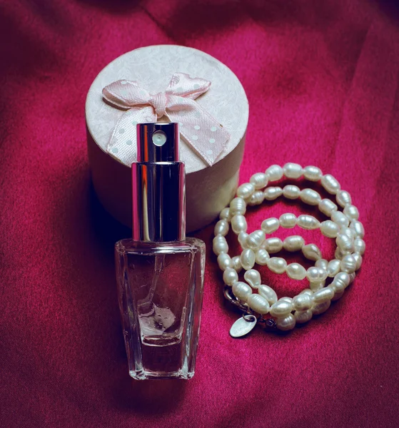 Női parfüm, egy rózsaszín háttér — Stock Fotó