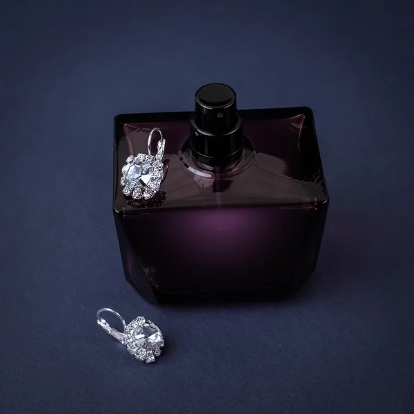 Diamond earrings and perfume — Stock Photo, Image