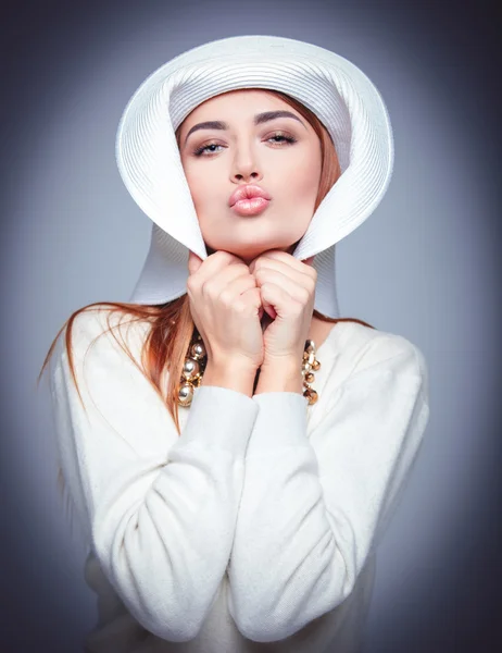 Beautiful girl in a white hat on a blue background — Stock Photo, Image