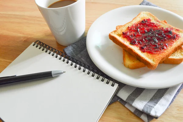Reggeli kávé és a kenyér a notebook — Stock Fotó