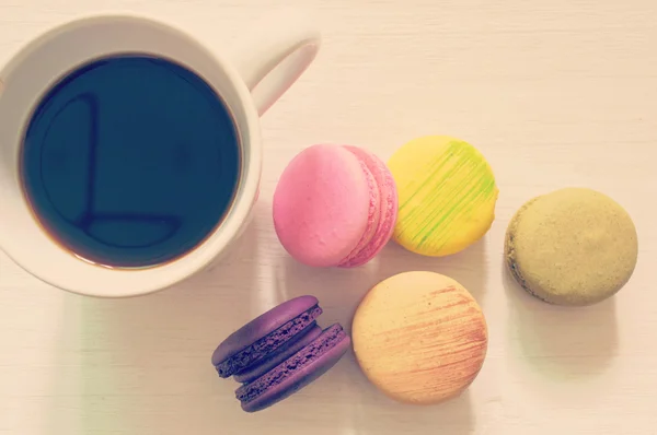 Macarons colorés reposent sur avec tasse à café — Photo