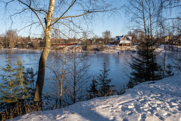 Soğuk ve güneşli bir günde, İvanovo 'daki Talka nehrinin buzundaki balıkçılar, Rusya. 