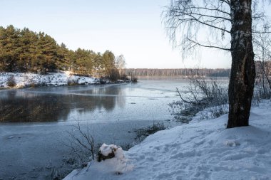 Rusya 'nın güneşli bir kış gününde, büyük bir su deposunun sessiz durgun gölündeki buz aynası..
