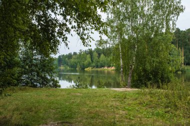 Bulutlu bir yaz gününde küçük bir rezervuarı olan güzel bir yaz manzarası. 