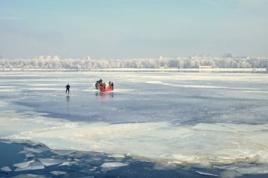 2017-18-01, Kyiv, Ukrayna. Kış boyunca donmuş nehirde şişme botlu kurtarma ekibi. Acil müdahale, buz kurtarma operasyonu, soğuk hava, tehlike ve güvenlik kavramı.