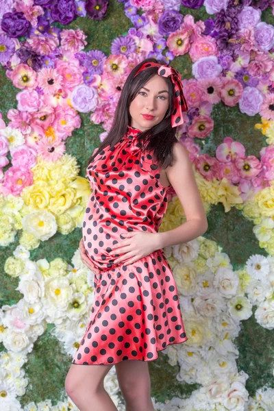 The pregnant woman in front of the flowers — Stock Photo, Image