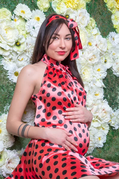 The pregnant woman in front of the flowers — Stock Photo, Image