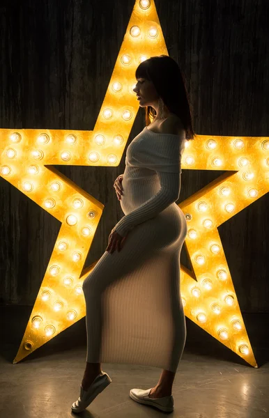Mulher grávida bonita na frente de uma estrela brilhante . — Fotografia de Stock