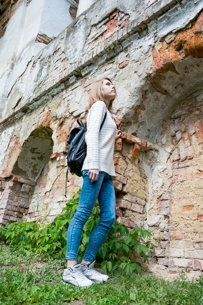 Chica de pie cerca de la pared destruida en un parque —  Fotos de Stock
