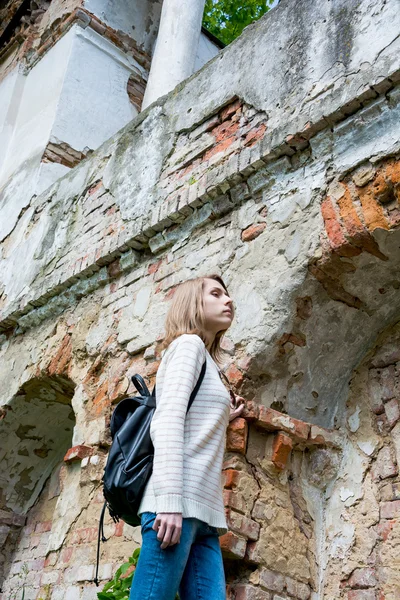 Chica de pie cerca de la pared destruida en un parque —  Fotos de Stock