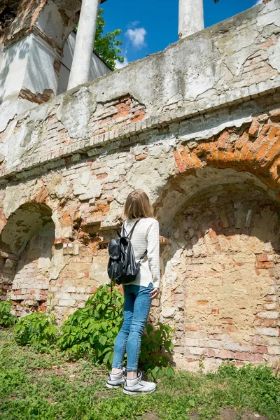 Girl standing near the destroyed wall in a park — Stock Photo, Image