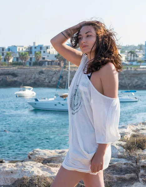 Beautiful woman in a white clothes in front of the sea — Stock Photo, Image