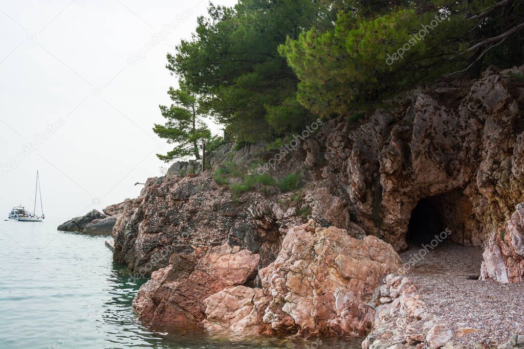 Cave in the Milocher park with a view to the King's Beach in Sveti Stefan in Montenegro