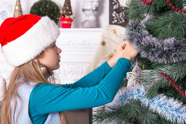 Chica en sombreros de santa decoración del árbol de Navidad —  Fotos de Stock