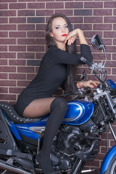 Mädchen im schwarzen Kleid auf einem Motorrad — Stockfoto