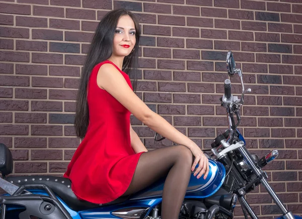 Ragazza in abito rosso su una moto — Foto Stock