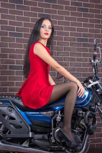 Fille en robe rouge sur une moto — Photo