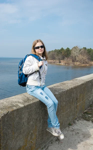 Una adolescente con una mochila frente al mar — Foto de Stock