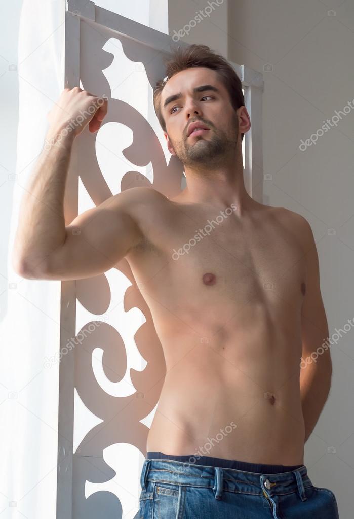 A shirtless young man is standing