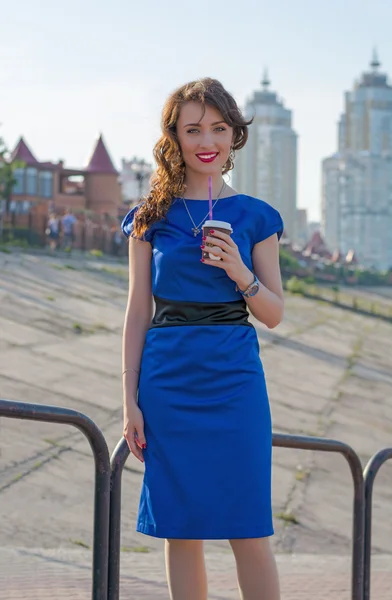 Beautiful girl is drinking coffee in front of buildings in a Eur — Stock Photo, Image