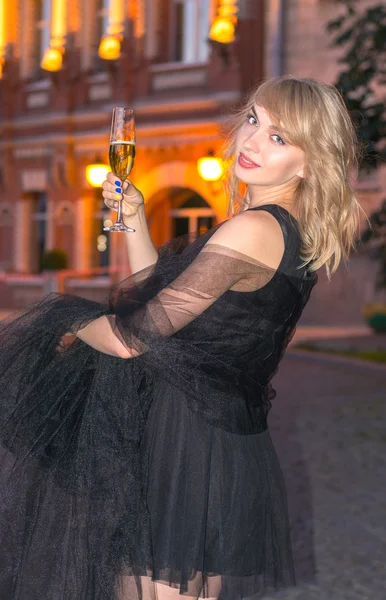 Mädchen mit einem Glas Champagner in der Stadt — Stockfoto