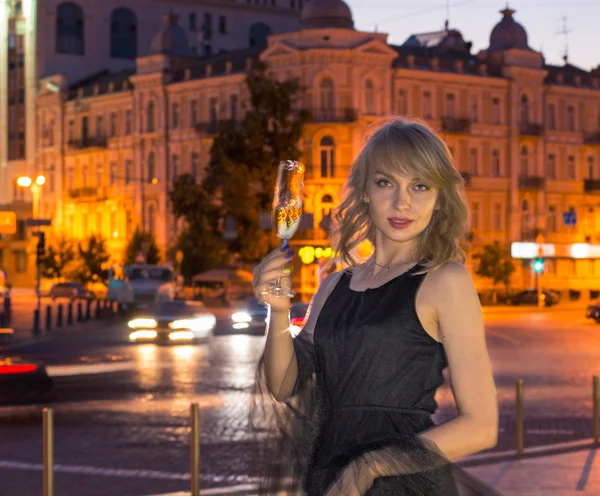 Girl with a glass of champagne in the city — Stock Photo, Image