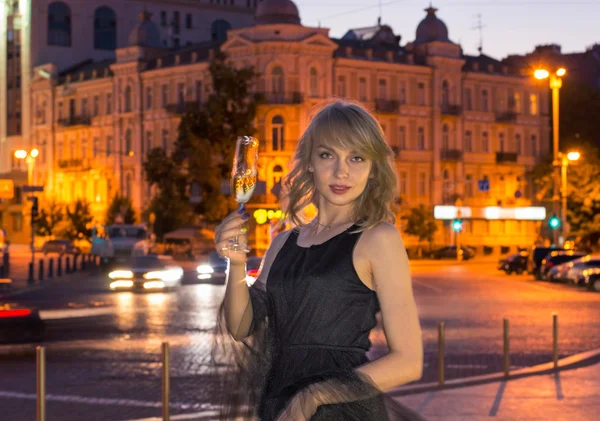 Mädchen mit einem Glas Champagner in der Stadt — Stockfoto