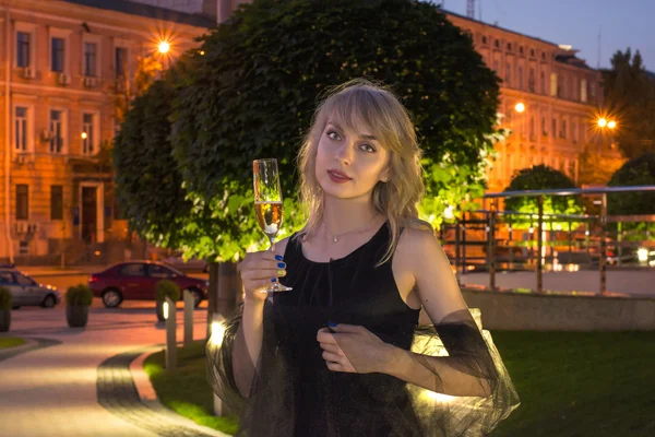 Mädchen mit einem Glas Champagner in der Stadt — Stockfoto