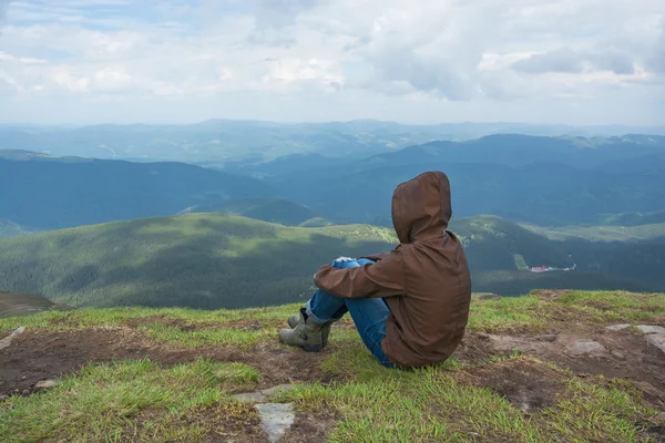 Girl is sitting on a mountain top — Stock Photo, Image